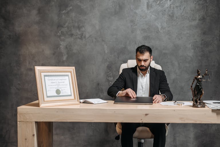 A bearded lawyer working at his office desk, showing professionalism and expertise.